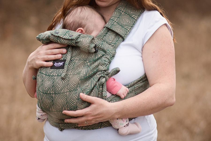 Novorozené miminko na břiše matky v šátkovém nosítku